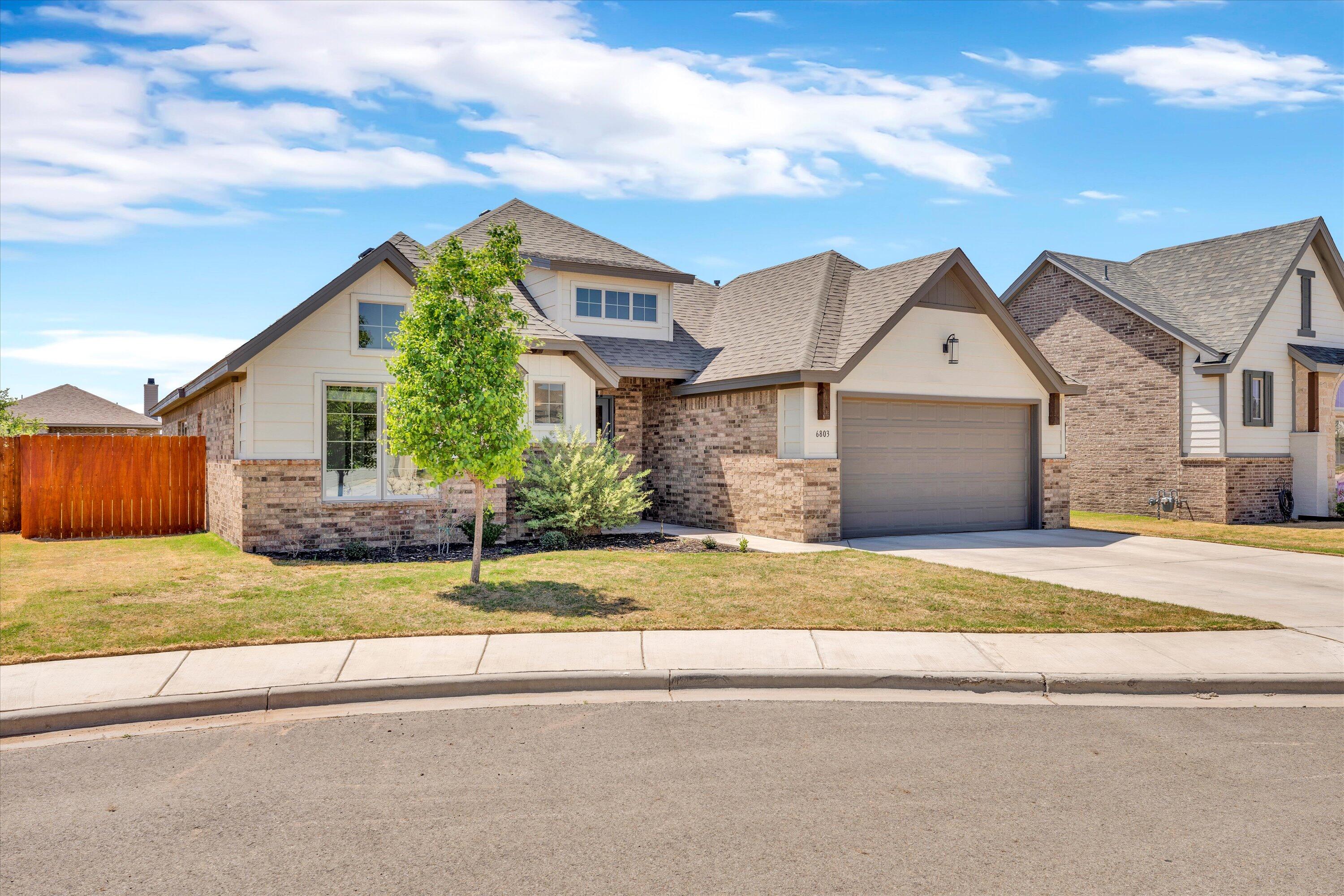 6803 52nd Street Lubbock, TX 79407 - Photo 29 of 34 a front view of a house with a garden and garage