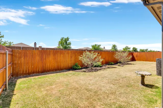 a view of a yard with wooden fence