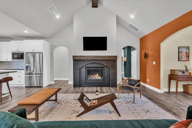 a living room with furniture a flat screen tv and a fireplace