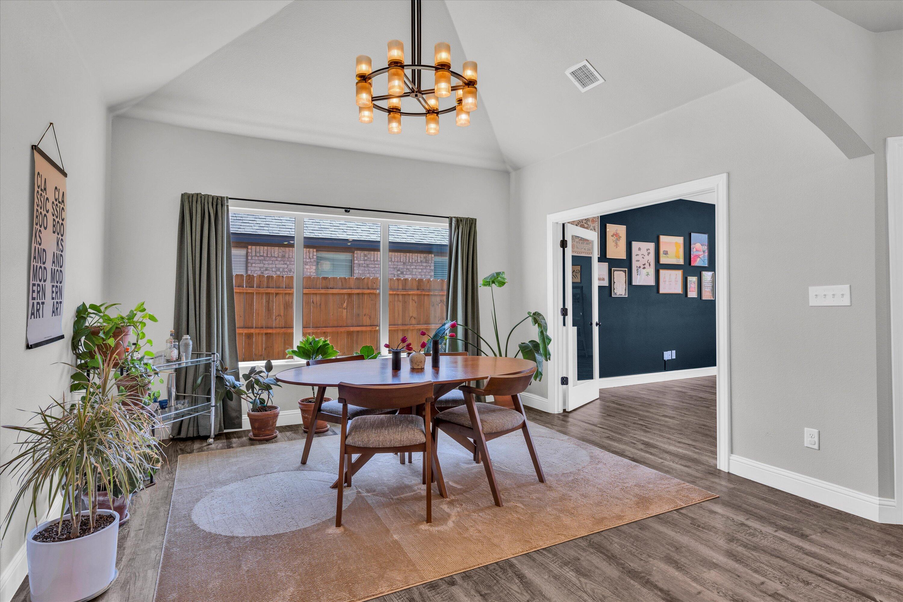 6803 52nd Street Lubbock, TX 79407 - Photo 9 of 34 a dining room with furniture potted plants and wooden floor
