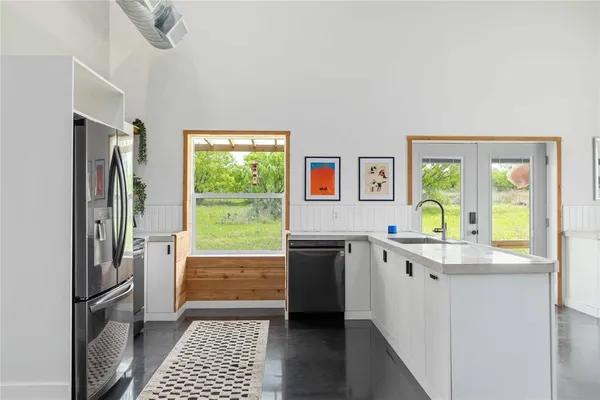 a kitchen with stainless steel appliances granite countertop a refrigerator and a sink