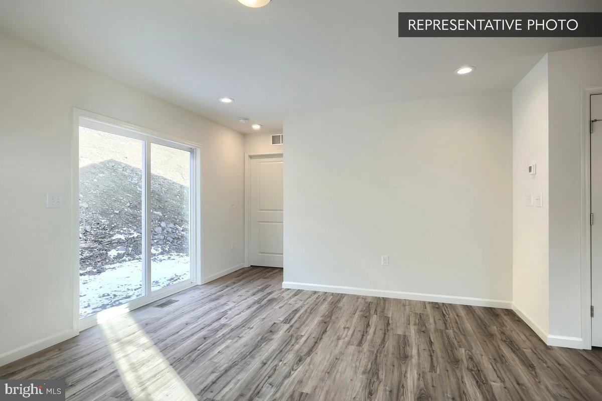 Sugar Maple Plan At Hills Spring Grove, PA 17362 - Photo 21 of 34 a view of an empty room with wooden floor and a window