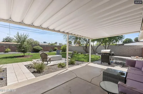 a view of a patio with couches table and chairs with wooden fence and plants