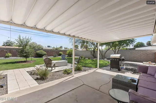 a view of a patio with couches table and chairs with wooden fence and plants