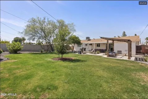 a view of a big house with a big yard and large trees