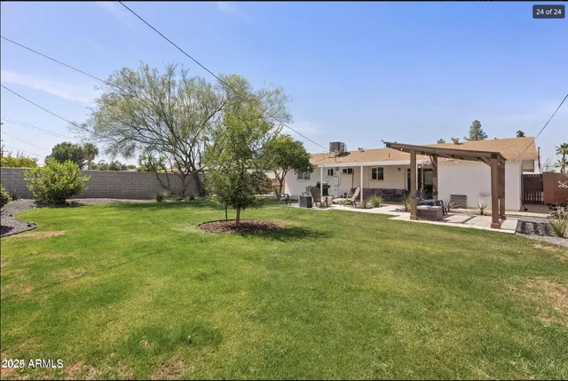 a view of a big house with a big yard and large trees