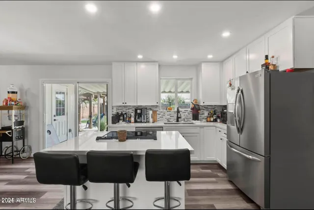 a kitchen with refrigerator and chairs