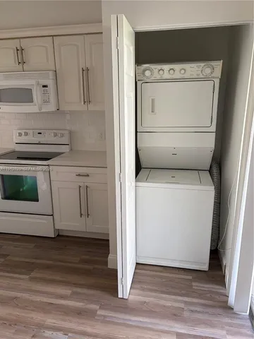 a utility room with cabinets washer and dryer