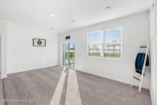 a view of an empty room with furniture and a window