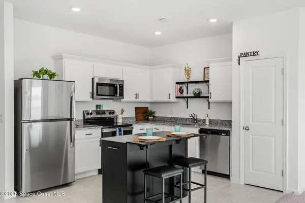 a kitchen with a refrigerator a stove a microwave and cabinets