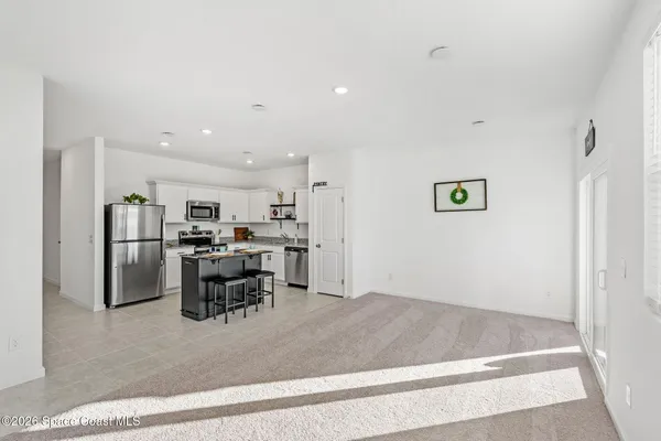 a view of a kitchen with furniture and stainless steel appliances