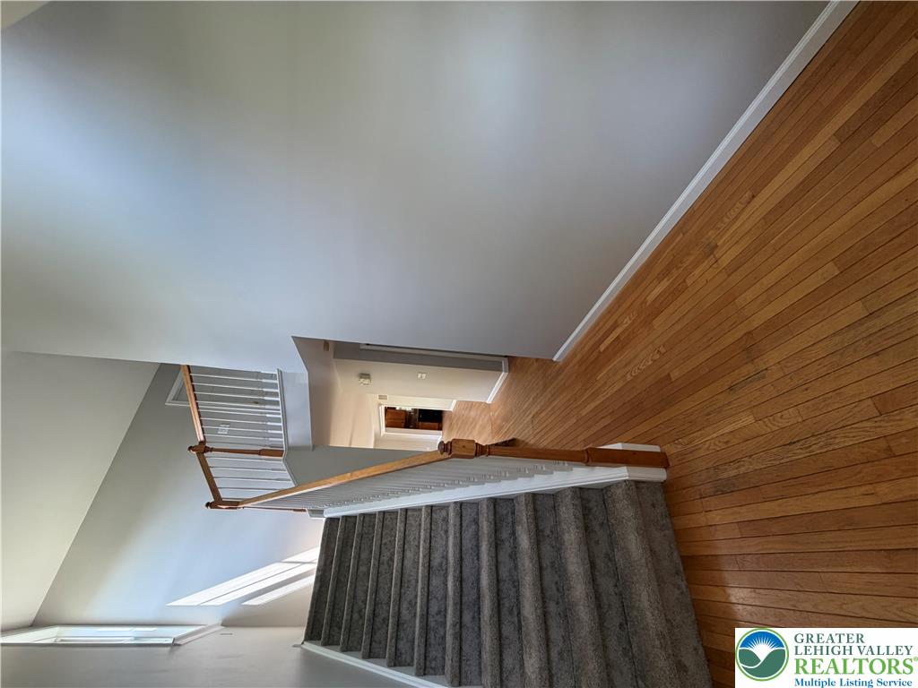 4157 Walter Road Bethlehem, PA 18020 - Photo 8 of 36 Sunlight graces the hardwood floors and carpeted stairs, leading to additional spaces.