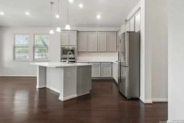 a kitchen with wooden floors and white cabinets
