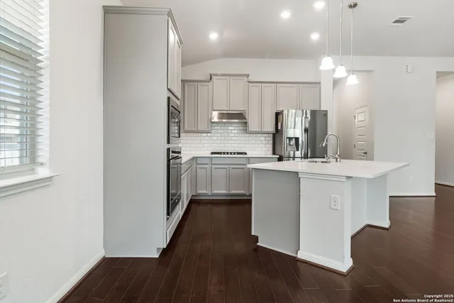 a kitchen with kitchen island white cabinets and stainless steel appliances