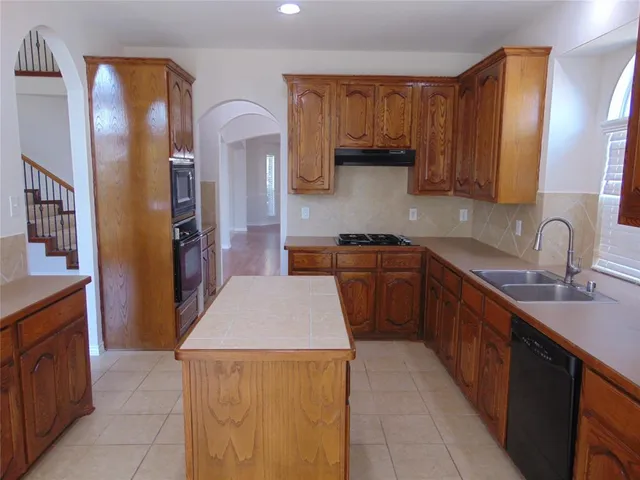 a view of an empty room with wooden floor fireplace and a window
