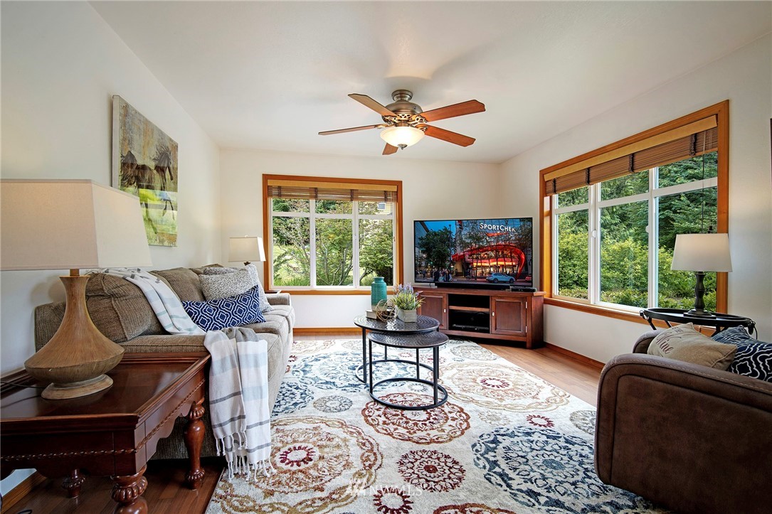 4826 200th Street Southeast Bothell, WA 98012 - Photo 22 of 40 a living room with furniture a flat screen tv and a large window
