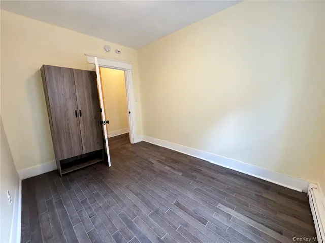 an empty room with wooden floor and mirror
