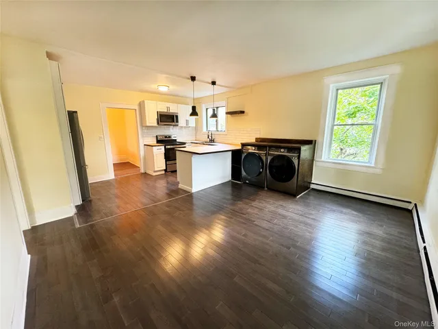 a living room with hard wood floors and a kitchen