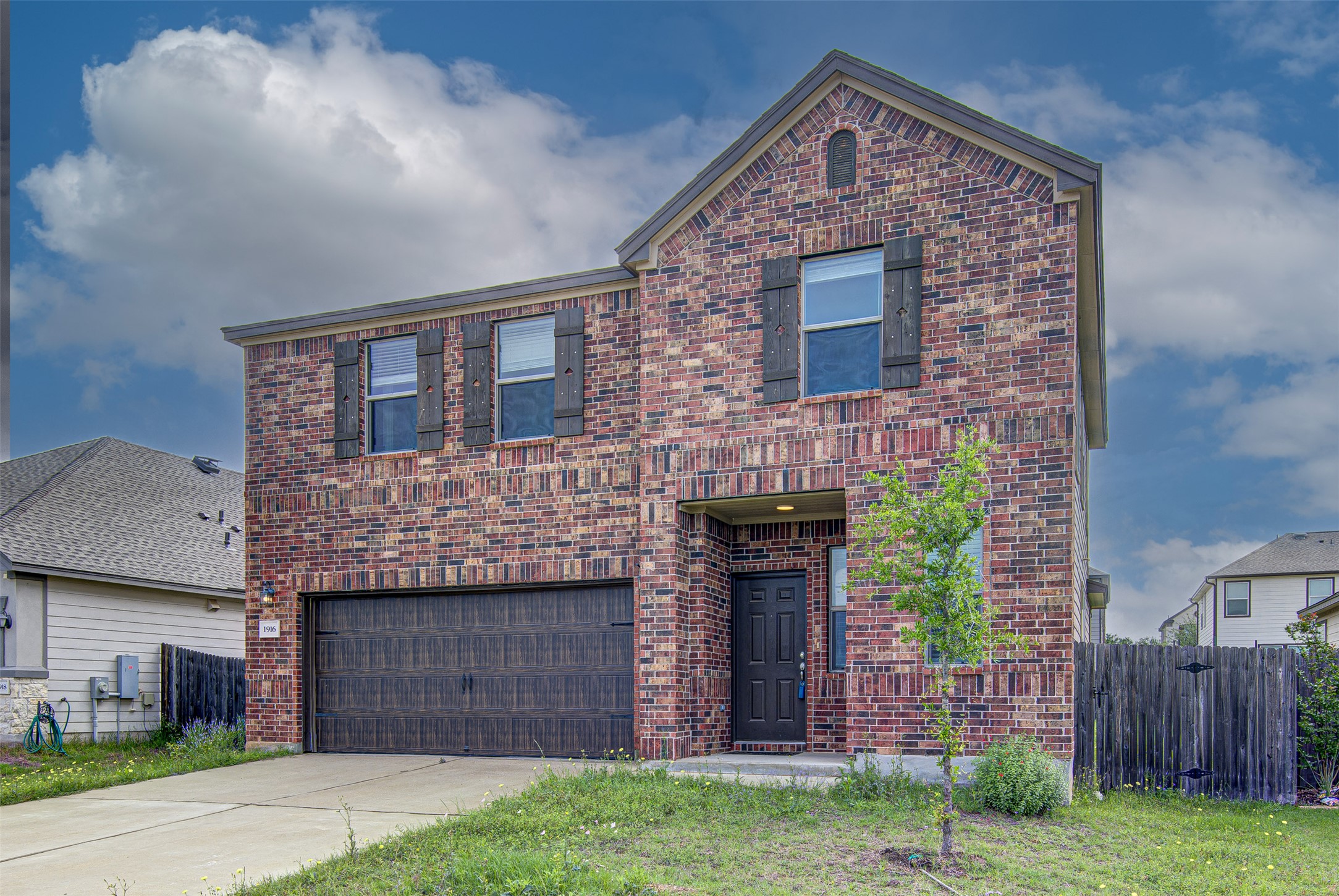 1916 Dragonfly Loop Bastrop, TX 78602 - Photo 2 of 33 a front view of a house with a garden