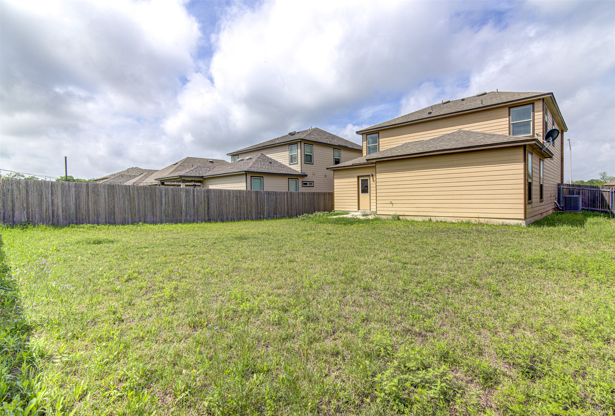 1916 Dragonfly Loop Bastrop, TX 78602 - Photo 29 of 33 a view of a house with a yard and a large tree