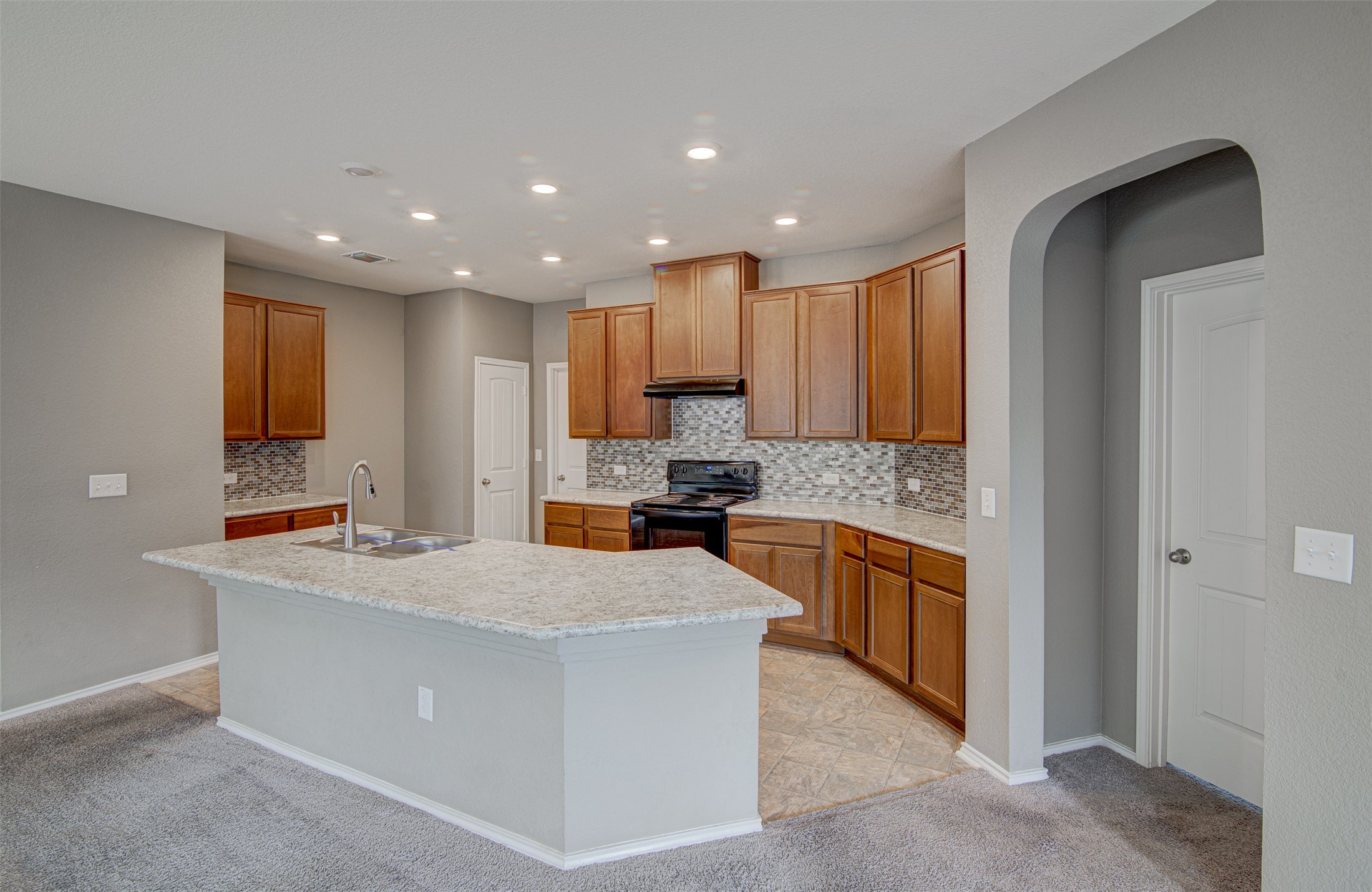 1916 Dragonfly Loop Bastrop, TX 78602 - Photo 5 of 33 a large kitchen with stainless steel appliances granite countertop a large counter top a stove a sink and a refrigerator