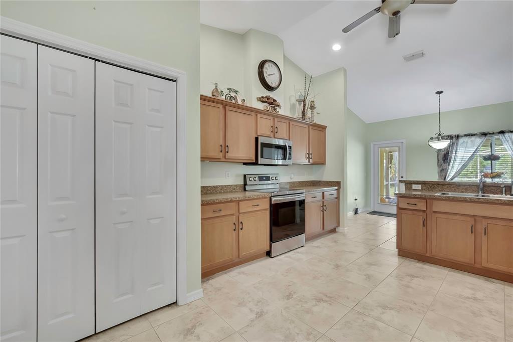 15157 Duck Hawk Road Weeki Wachee, FL 34614 - Photo 11 of 48 a large kitchen with cabinets stainless steel appliances and a fireplace