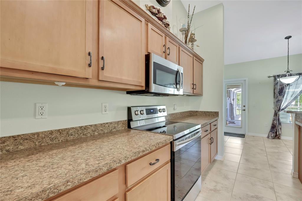 15157 Duck Hawk Road Weeki Wachee, FL 34614 - Photo 12 of 48 a kitchen with granite countertop a sink a stove top oven and cabinets