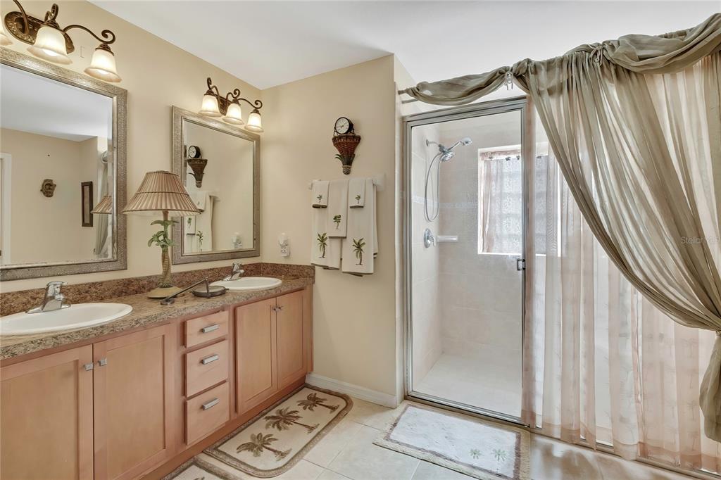 15157 Duck Hawk Road Weeki Wachee, FL 34614 - Photo 21 of 48 a spacious bathroom with a granite countertop sink and a mirror