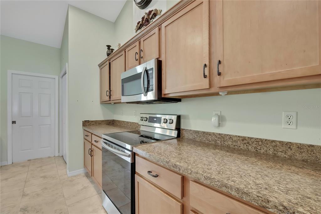 15157 Duck Hawk Road Weeki Wachee, FL 34614 - Photo 8 of 48 a kitchen with stainless steel appliances granite countertop a sink a stove and microwave