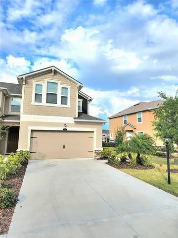 a front view of a house with a garden and mountain view