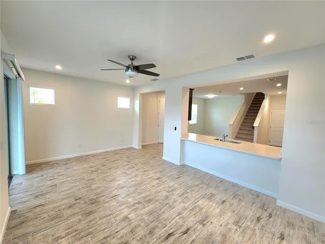 a view of a livingroom with a ceiling fan and wooden floor