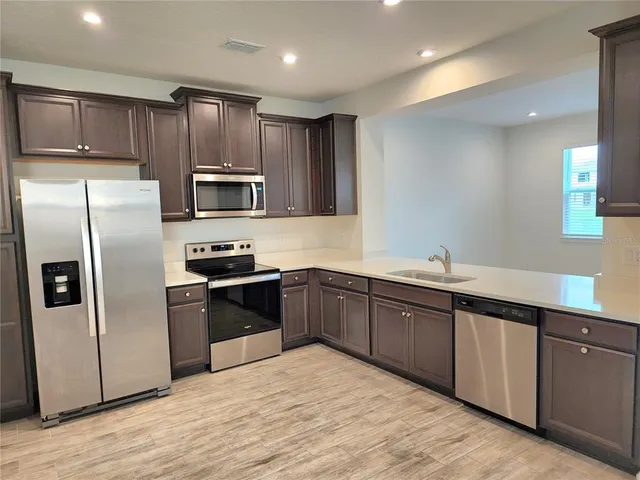 a kitchen with granite countertop stainless steel appliances and wooden cabinets