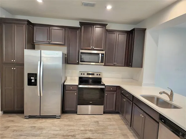 a kitchen with wooden cabinets and stainless steel appliances