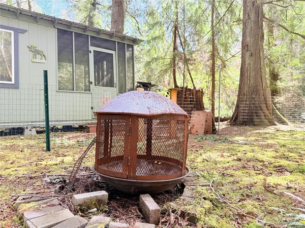 a view of a backyard with table and chairs and wooden fence