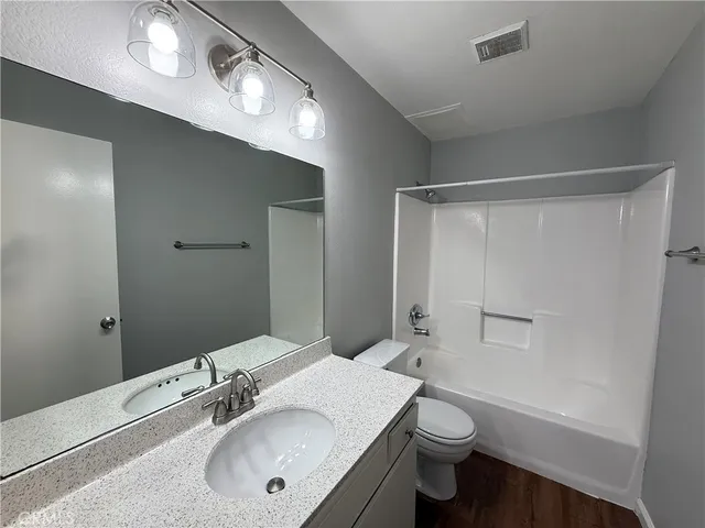 a bathroom with a sink vanity mirror and toilet
