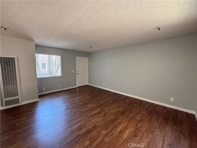 an empty room with wooden floor and window