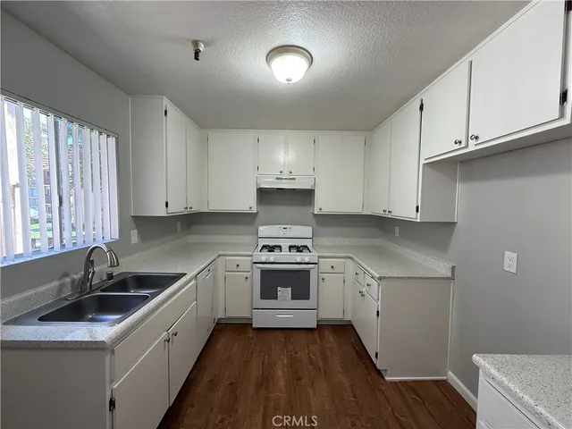 a kitchen with a sink stove and cabinets