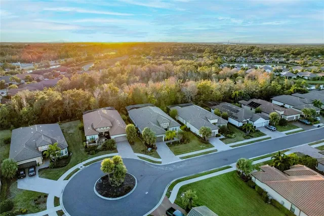 a front view of a house with garden and trees