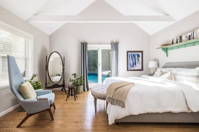 a spacious bedroom with a bed a table and a potted plant