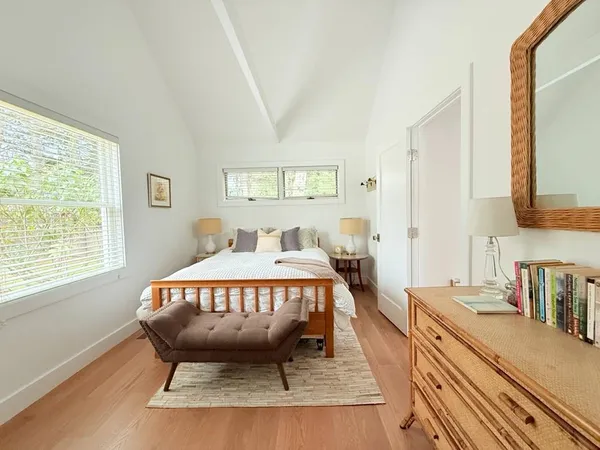 a bed sitting in a bedroom next to a window