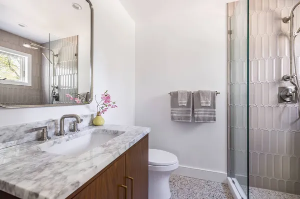a bathroom with a granite countertop sink and a mirror