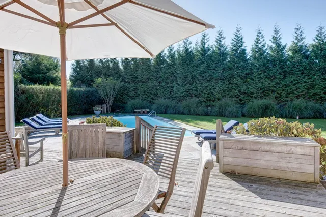 a backyard of a house with wooden floor and outdoor seating