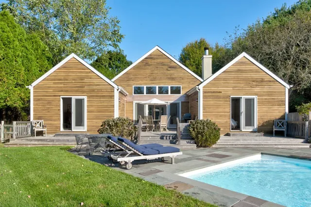 a view of a house with a yard chairs and a table