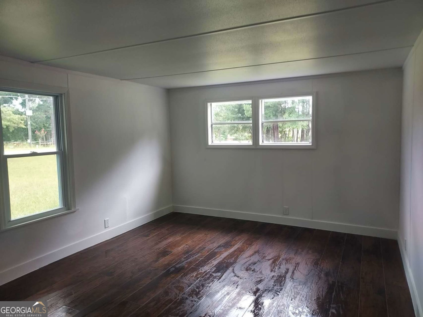 514 Phillips Road Warm Springs, GA 31830 - Photo 15 of 36 an empty room with wooden floor and windows