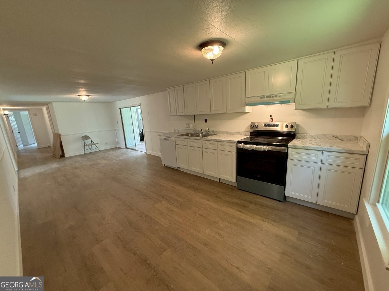 514 Phillips Road Warm Springs, GA 31830 - Photo 3 of 36 a kitchen with stainless steel appliances granite countertop a stove a sink a refrigerator white cabinets and couches with wooden floor