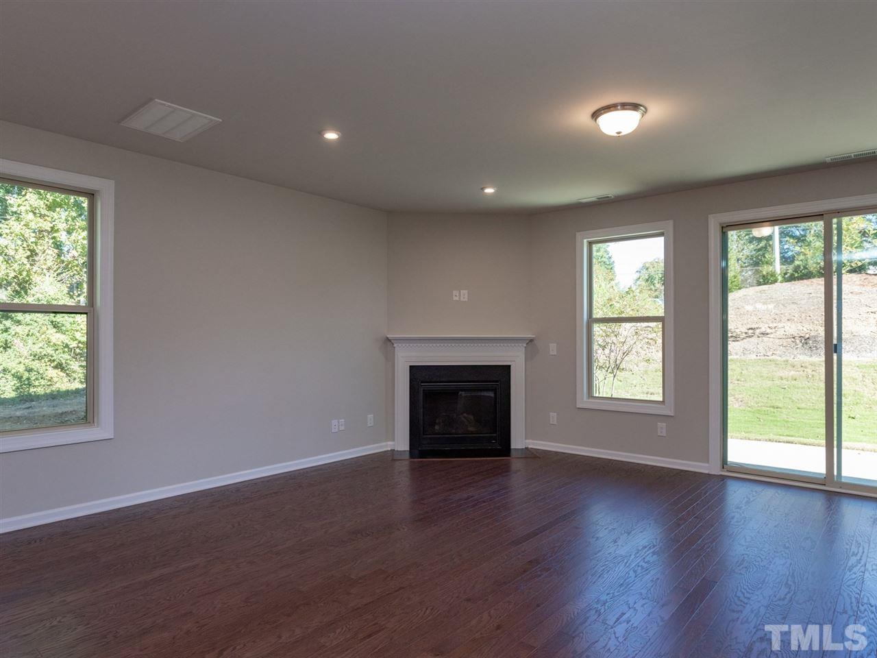 845 Rymark Court Cary, NC 27513 - Photo 11 of 21 an empty room with wooden floor fireplace and windows