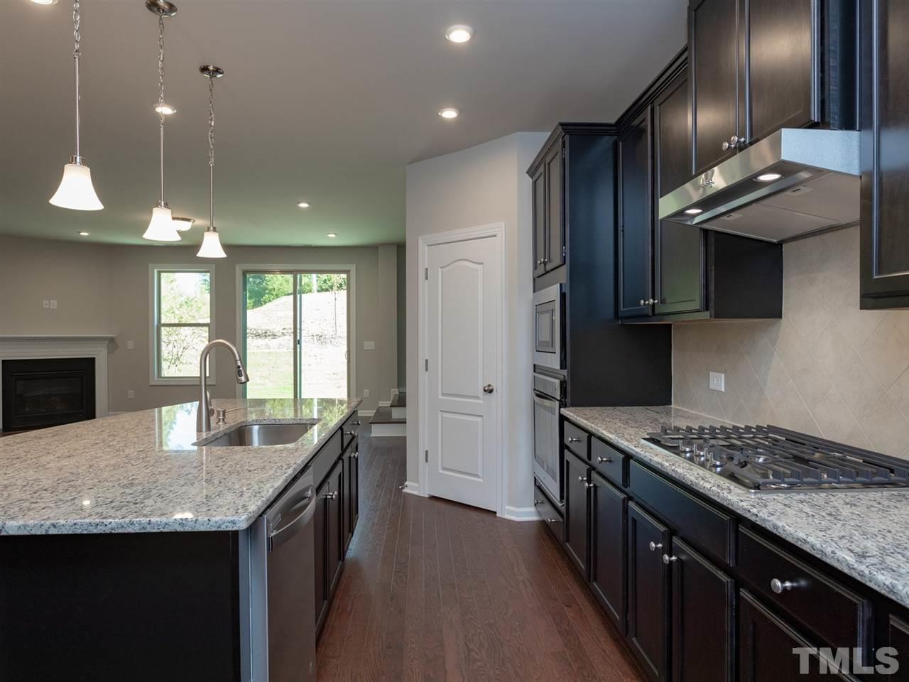 845 Rymark Court Cary, NC 27513 - Photo 4 of 21 a kitchen with granite countertop kitchen island stainless steel appliances a sink stove and cabinets