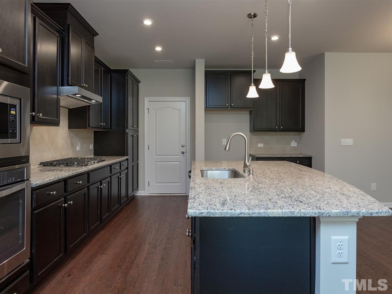 845 Rymark Court Cary, NC 27513 - Photo 6 of 21 a kitchen with kitchen island granite countertop a sink stainless steel appliances and cabinets