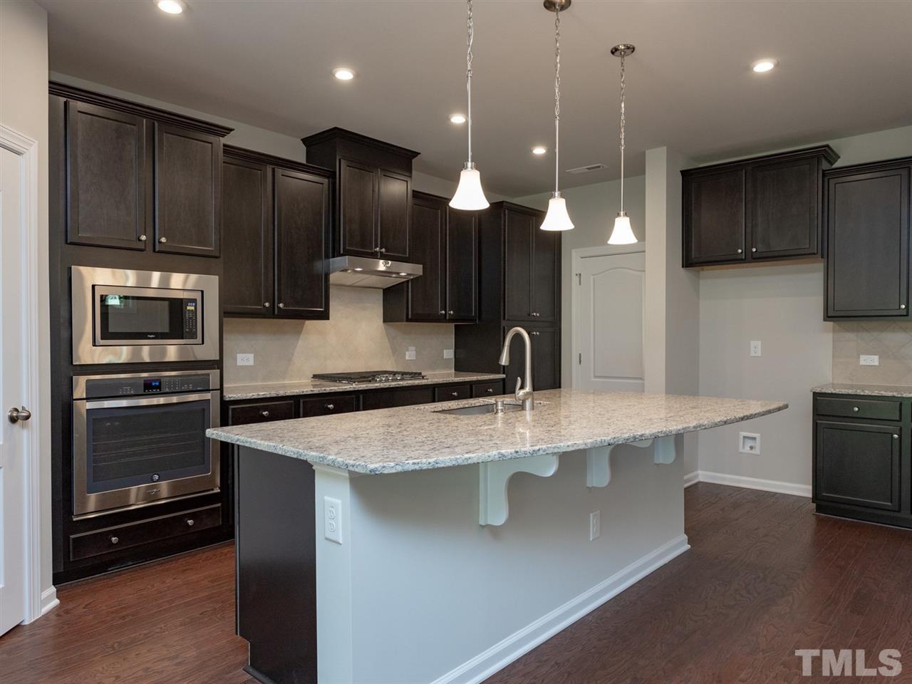 845 Rymark Court Cary, NC 27513 - Photo 7 of 21 a large kitchen with a large kitchen island a sink stainless steel appliances and cabinets