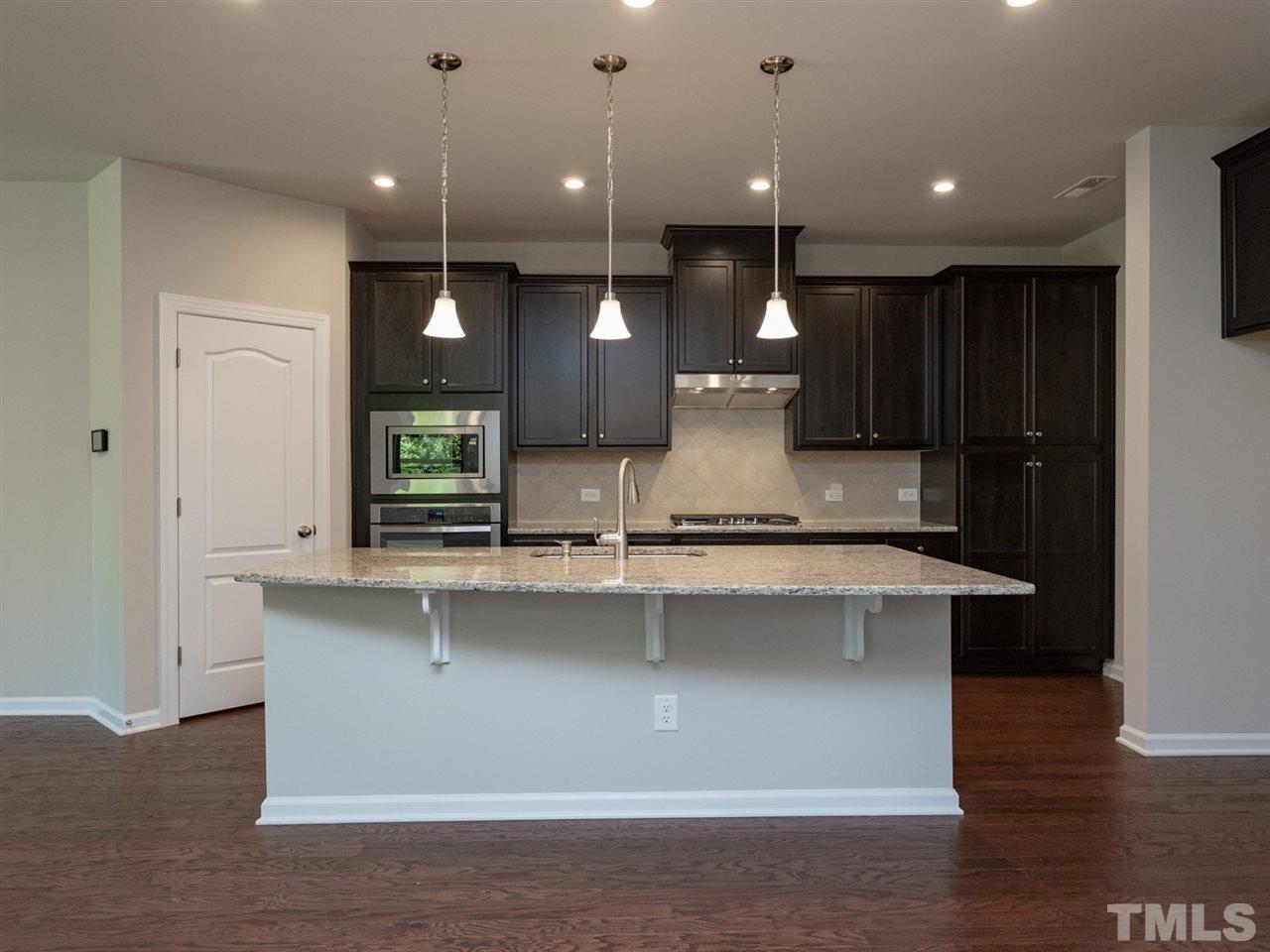 845 Rymark Court Cary, NC 27513 - Photo 8 of 21 a large kitchen with stainless steel appliances a large counter top a sink a refrigerator and a window